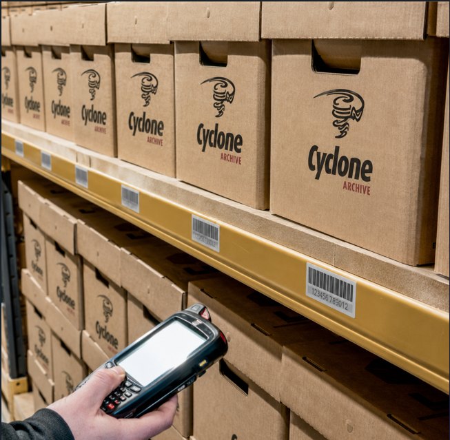 A handheld scanner reading a box barcode on the shelf